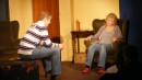 Removal man Steve (Henry Cockburn) stops and sits on a trunk to chat with May (Lesley Anderson).